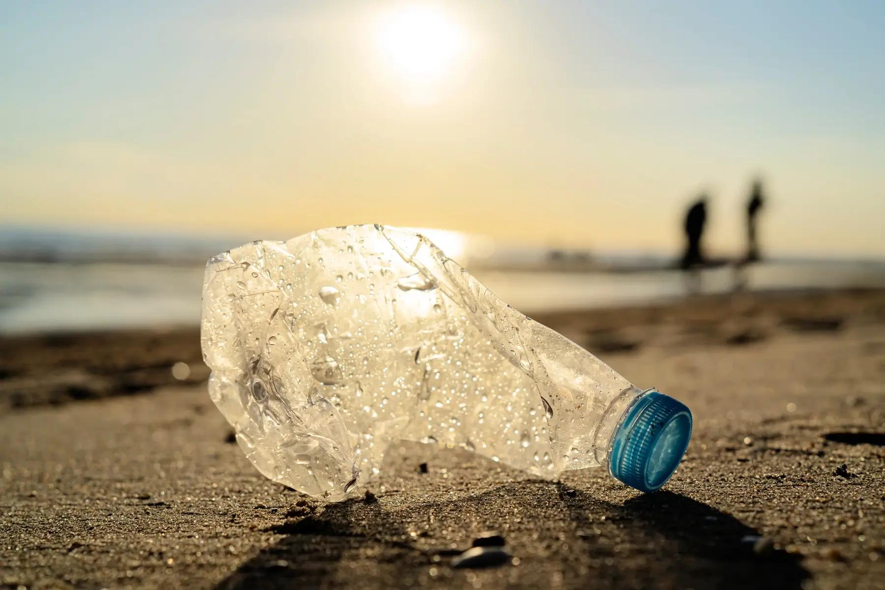Botella de plástico en un basurero con fondo borroso de naturaleza